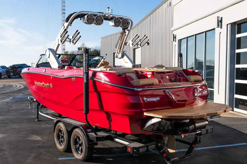 Slide: The Image of 2022 MasterCraft X24 boat in vibrant red, parked on a trailer near a building. - 4