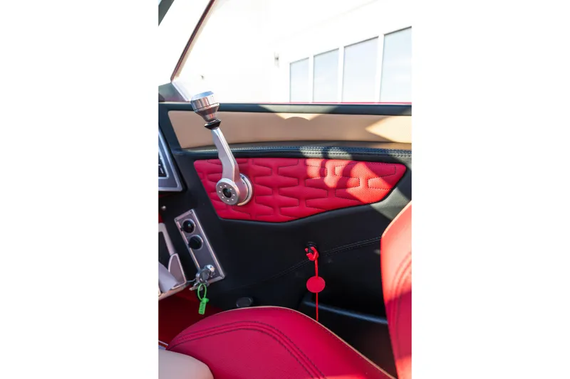 Slide: The Image of 2022 MasterCraft X24 interior with red and black upholstery, featuring a sleek control lever. - 47