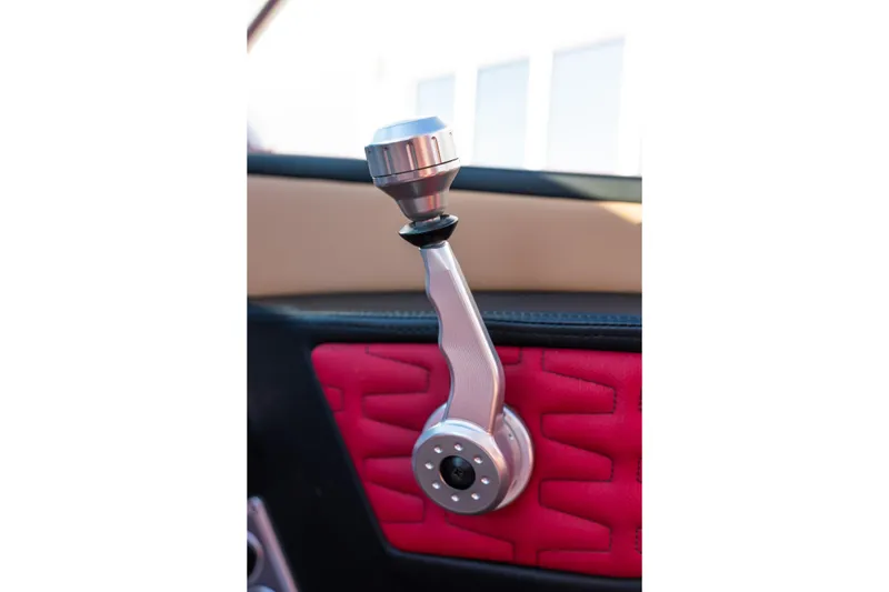 Slide: The Image of Close-up of 2022 MasterCraft X24 boat throttle lever with red and beige interior. - 48