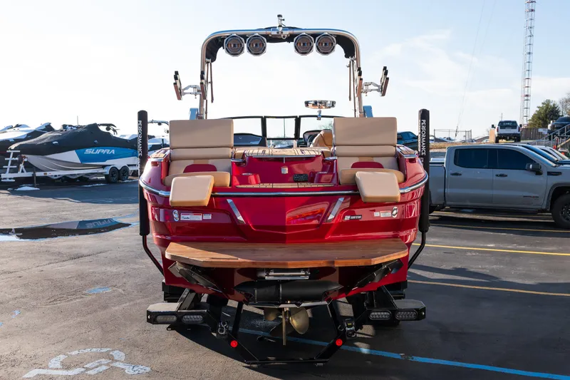 Slide: The Image of 2022 MasterCraft X24 boat, red exterior, parked in a marina with other boats. - 5