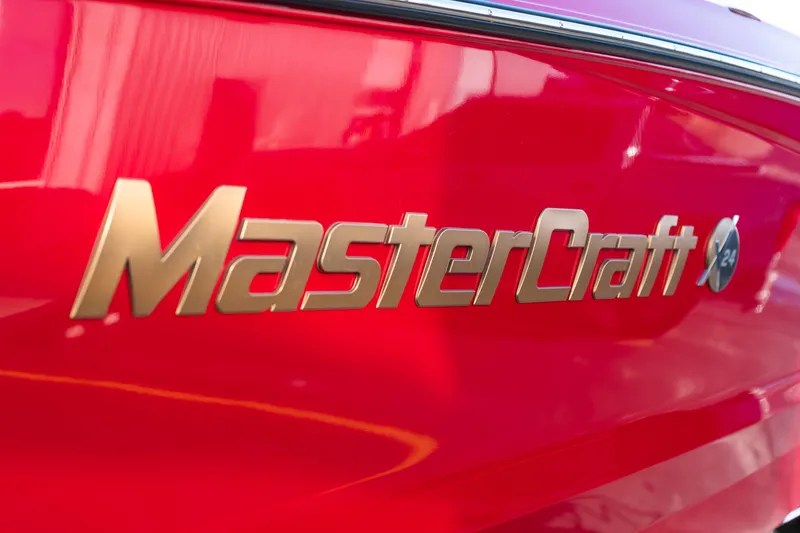Slide: The Image of Red 2022 MasterCraft X24 boat with gold logo detail. - 50