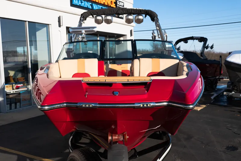 Slide: The Image of 2022 MasterCraft X24 boat in vibrant red, parked outside a marine dealership. - 52