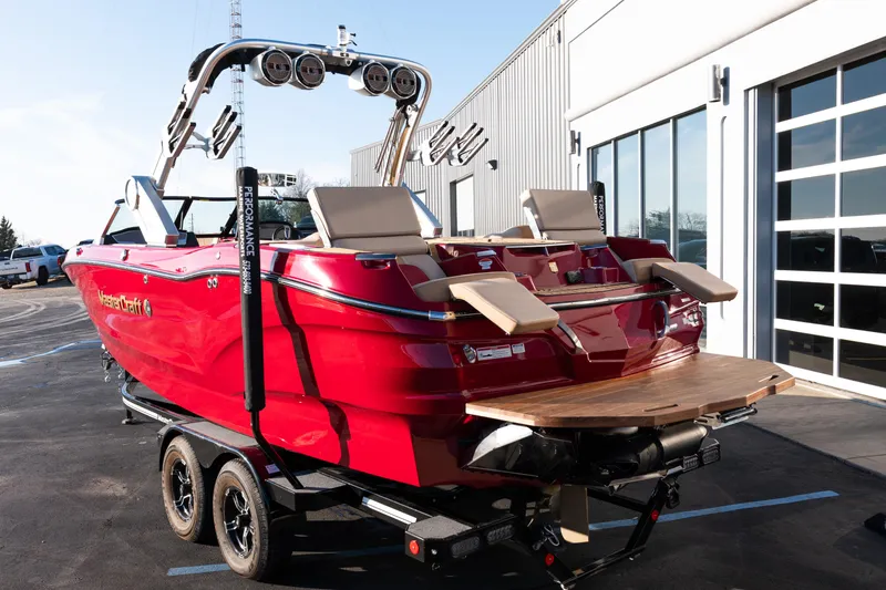 Slide: The Image of 2022 MasterCraft X24 boat in vibrant red, parked on a trailer near a modern building. - 6
