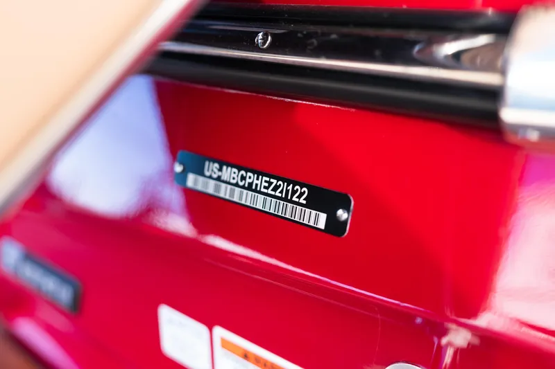 Slide: The Image of 2022 MasterCraft X24 boat identification plate on red surface. - 9