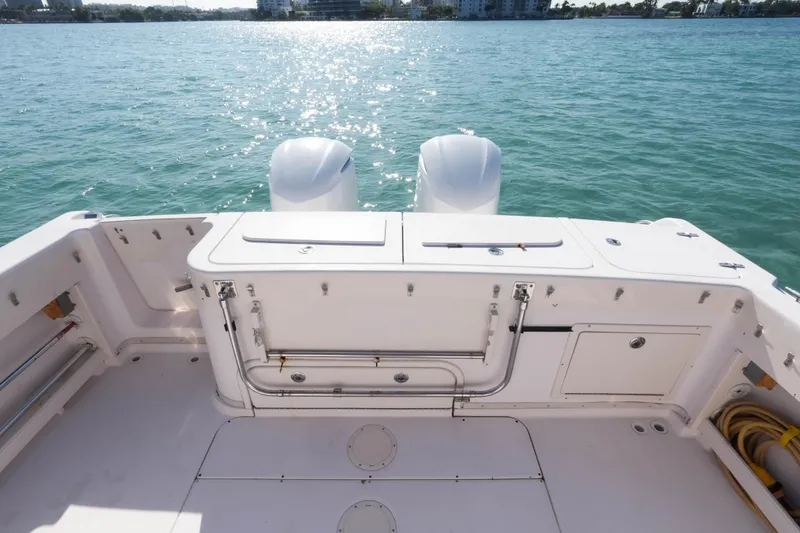 Slide: The Image of 2003 Grady-White Express 330 boat deck with twin engines on calm water. - 17