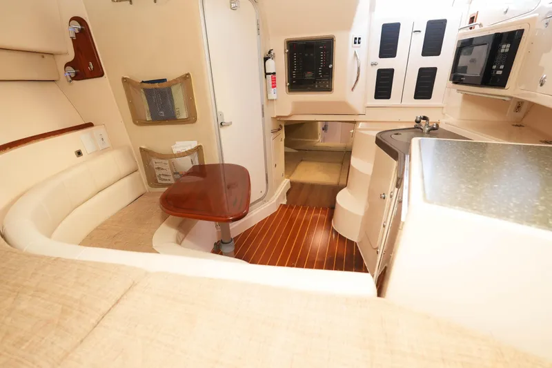Slide: The Image of 2003 Grady-White Express 330 cabin interior with seating, kitchenette, and wood flooring. - 23