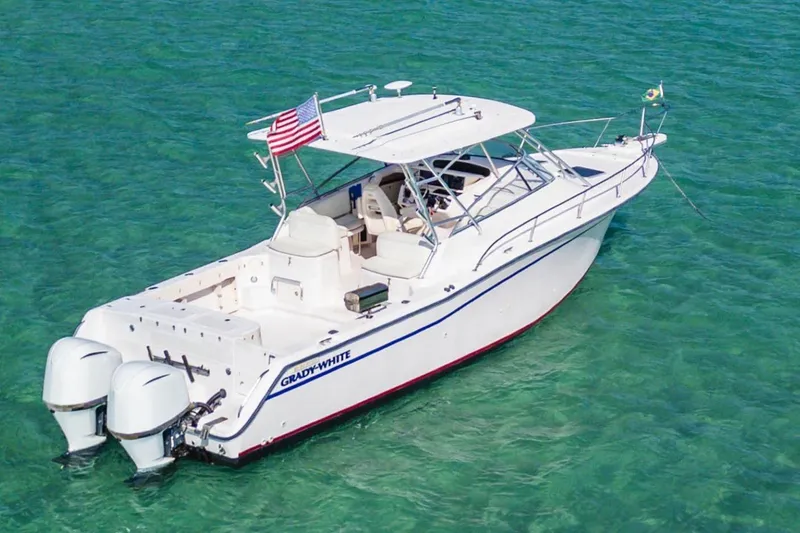 Slide: The Image of 2003 Grady-White Express 330 boat on clear turquoise water, featuring dual outboard engines. - 4