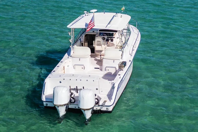 Slide: The Image of 2003 Grady-White Express 330 boat on clear turquoise water, rear view. - 6
