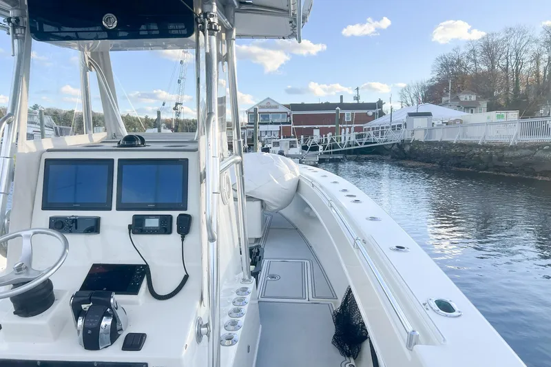 Slide: The Image of 2002 Contender 36 Open boat with dual screens, docked by a scenic waterfront. - 10