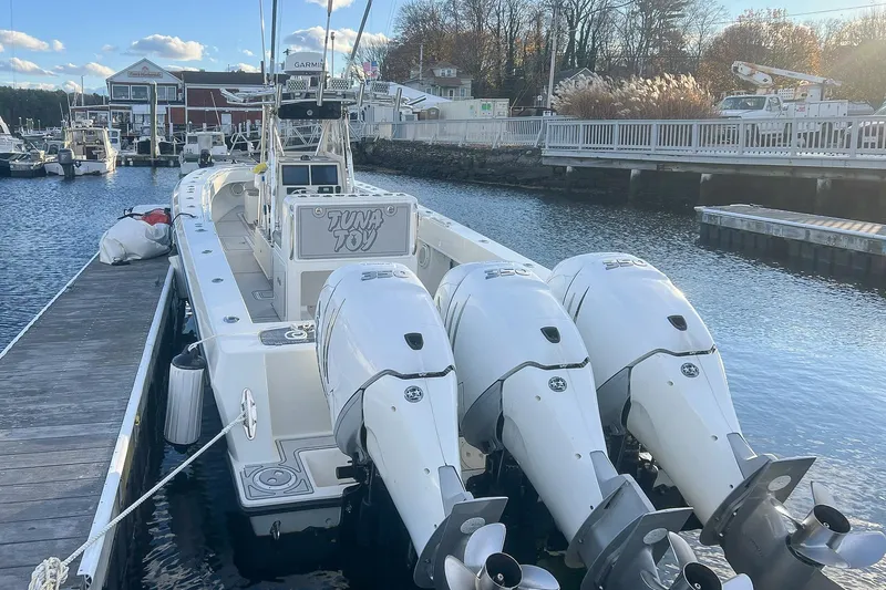 Slide: The Image of 2002 Contender 36 Open boat docked with triple outboard engines. - 3