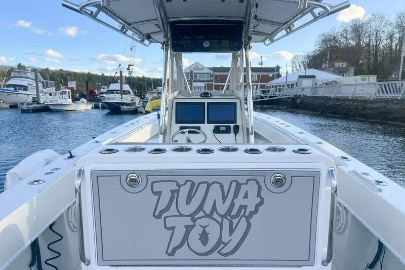 Slide: The Image of 2002 Contender 36 Open boat named "Tuna Toy" docked at a marina. - 7