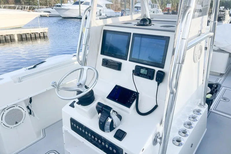 Slide: The Image of 2002 Contender 36 Open boat console with navigation screens and controls at marina. - 8