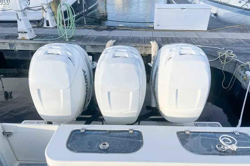 Slide: The Image of Triple Mercury outboard engines on a 2002 Contender 36 Open boat at dock. - 9