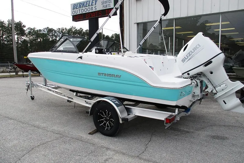 Slide: The Image of 2026 Stingray 172 DC boat with Suzuki outboard motor on a trailer at Berkeley Outdoors. - 2