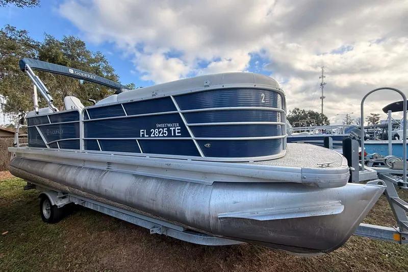 The Image of 2021 Sweetwater 2286 SB pontoon boat on trailer, blue and silver design. - 1