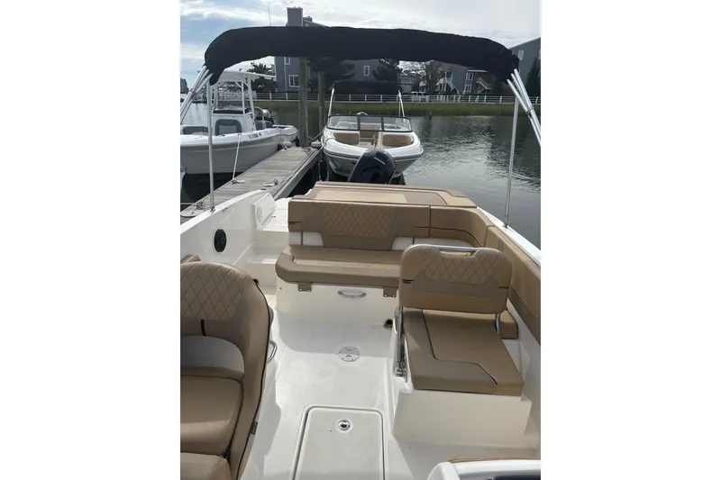 Slide: The Image of 2025 Bayliner VR6 Bowrider OB with tan seating, docked by the water. - 5