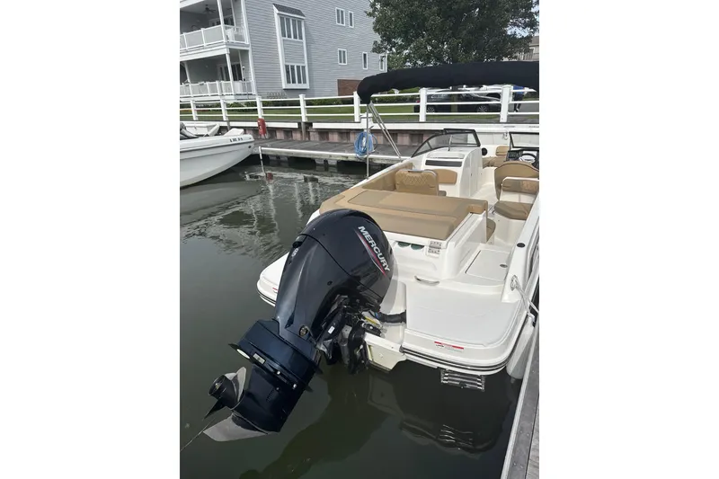 Slide: The Image of 2025 Bayliner VR6 Bowrider OB docked, featuring a powerful Mercury outboard engine. - 7
