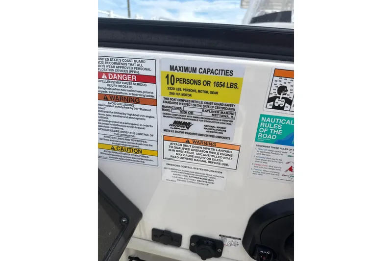 Slide: The Image of 2025 Bayliner VR6 Bowrider OB capacity and safety labels on boat dashboard. - 9
