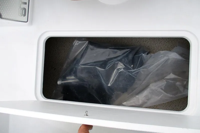 Slide: The Image of Storage compartment of 2026 Stingray 191 DC boat, featuring a plastic-covered item. - 17