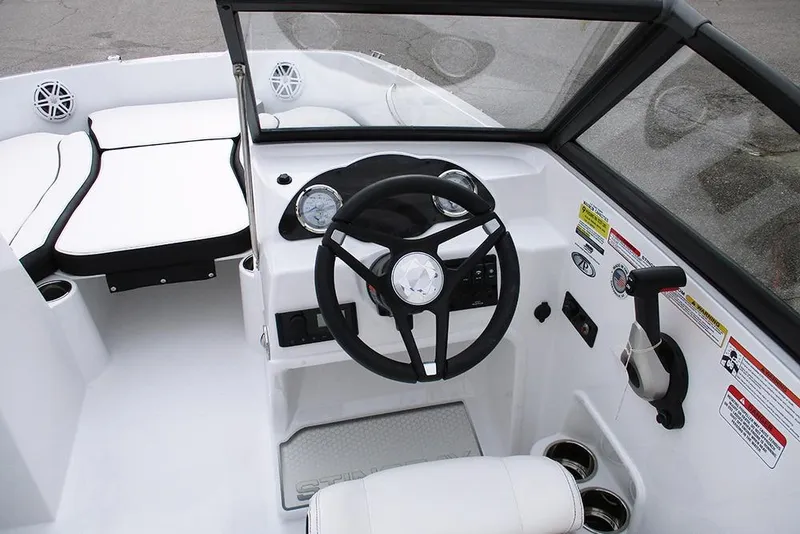 Slide: The Image of 2026 Stingray 191 DC boat interior with steering wheel and seating area. - 18