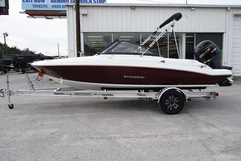 Slide: The Image of 2026 Stingray 191 DC boat on trailer, parked outside a building. - 6