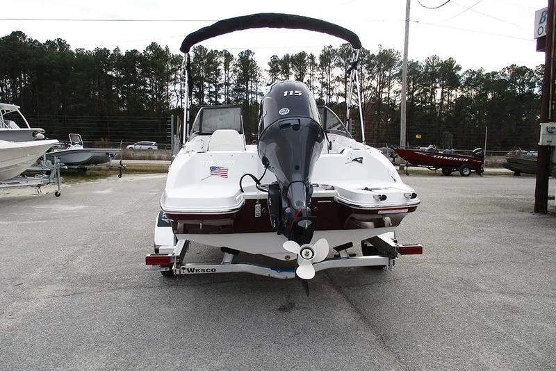 Slide: The Image of 2026 Stingray 191 DC boat with outboard motor on trailer, parked outdoors. - 8
