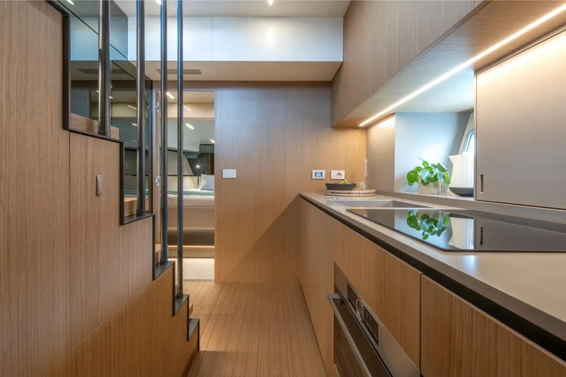 Slide: The Image of Modern interior of 2025 Bluegame BG54 yacht with sleek kitchen design and wooden finishes. - 12