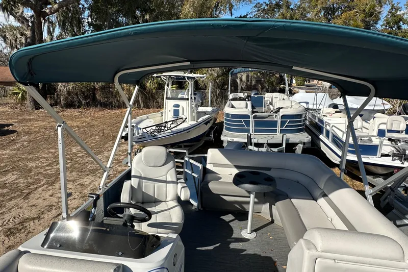 Slide: The Image of 2022 Sweetwater 2086 CX pontoon boat with canopy and seating, parked on land. - 8