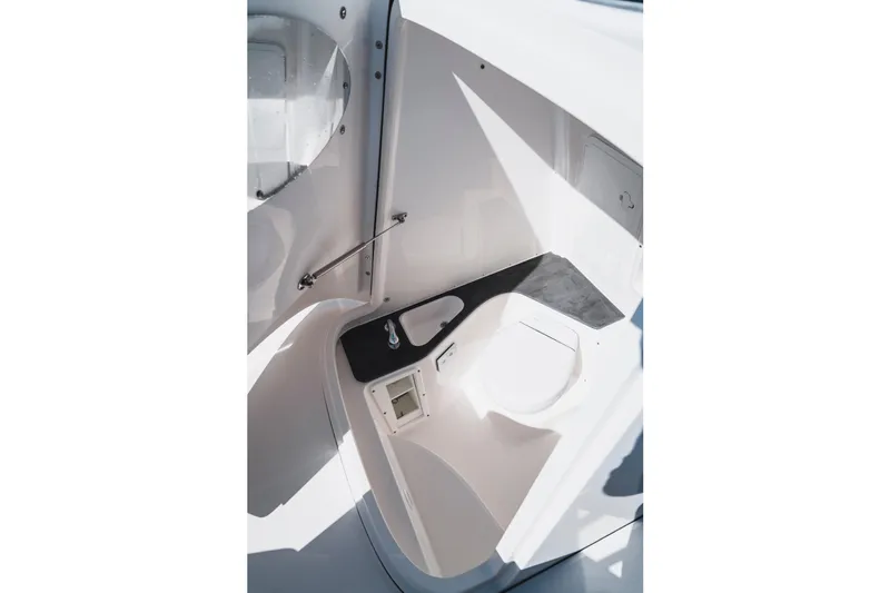 Slide: The Image of Interior of 2026 Edgewater 262CC boat, featuring a compact marine toilet setup. - 13