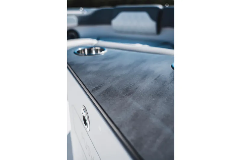 Slide: The Image of 2026 Edgewater 262CC boat interior with sleek black surface and cup holder. - 20