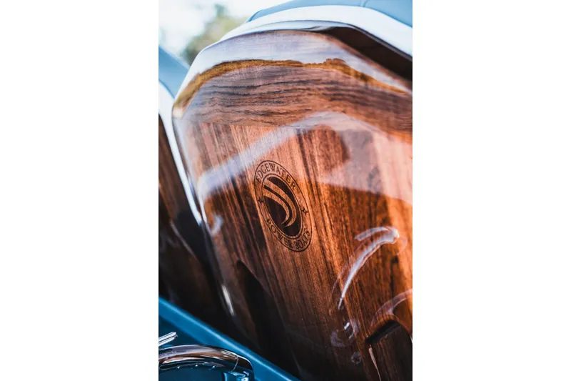 Slide: The Image of Close-up of 2026 Edgewater 262CC boat's polished wooden detail with logo. - 9