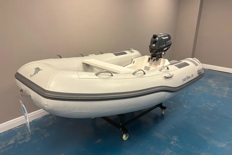 Slide: The Image of 2024 Caribe L-8 inflatable boat with Yamaha motor displayed indoors. - 2