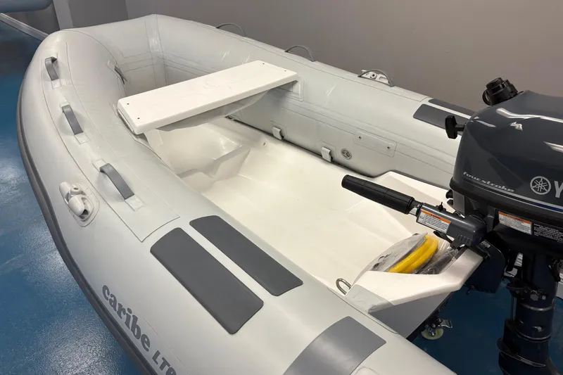 Slide: The Image of 2024 Caribe L-8 inflatable boat with Yamaha 4 motor displayed indoors. - 4