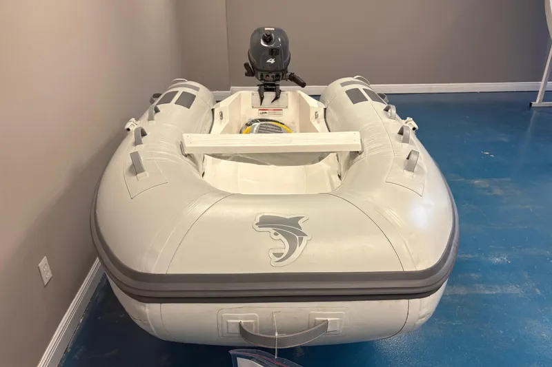 Slide: The Image of 2024 Caribe L-8 inflatable boat with Yamaha 4 motor displayed indoors. - 5