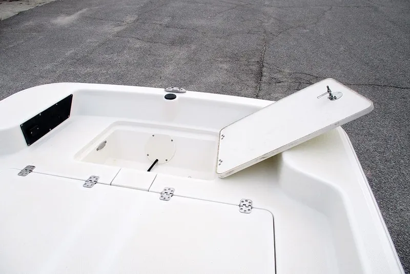 Slide: The Image of 2024 Mako Pro Skiff 15 CC boat storage compartment with open hatch. - 12