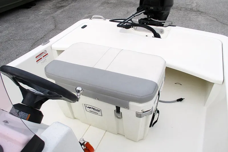Slide: The Image of 2024 Mako Pro Skiff 15 CC boat interior with steering wheel and seating. - 16