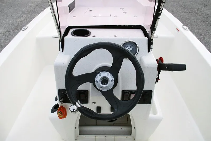 Slide: The Image of 2024 Mako Pro Skiff 15 CC boat console with steering wheel and controls. - 18