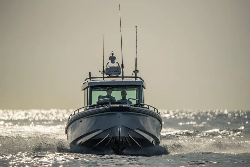 Slide: The Image of 2022 Axopar 28 Cabin boat deck with stainless steel railings and anchor. - 19