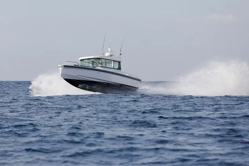 Slide: The Image of Interior of 2022 Axopar 28 Cabin boat with modern seating and large windows. - 20