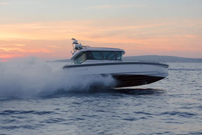 Slide: The Image of Open storage compartment on 2022 Axopar 28 Cabin boat with cleaning supplies. - 22