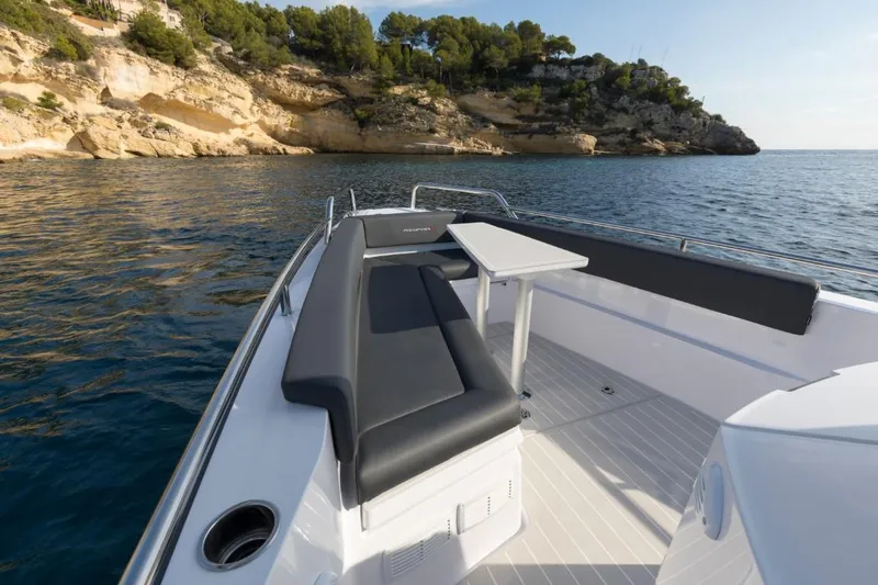 Slide: The Image of 2022 Axopar 28 Cabin boat on trailer, parked outdoors with palm trees in background. - 5