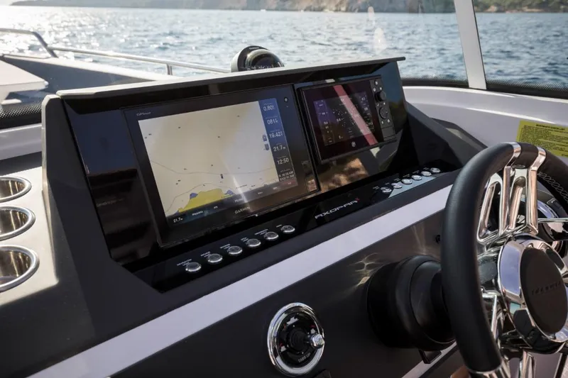 Slide: The Image of 2022 Axopar 28 Cabin interior with teal seating and modern dashboard. - 9