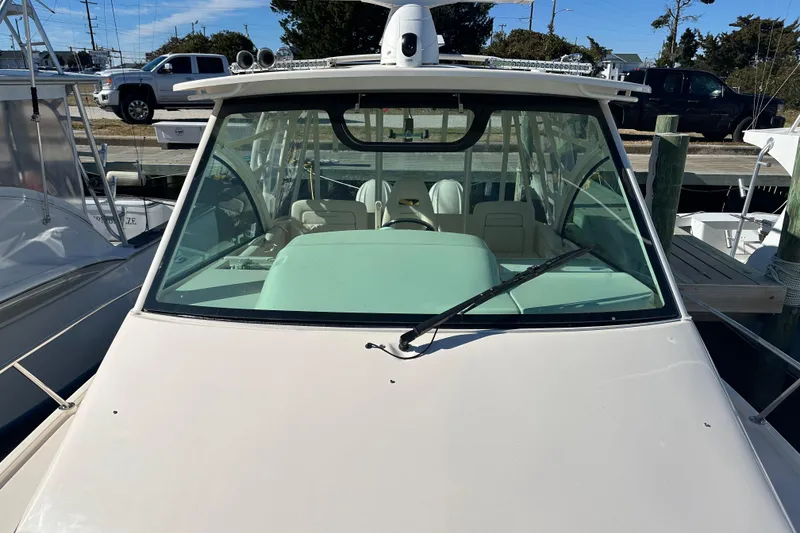 Slide: The Image of 2024 Grady-White Express 330 boat docked, front view with windshield and wiper. - 11