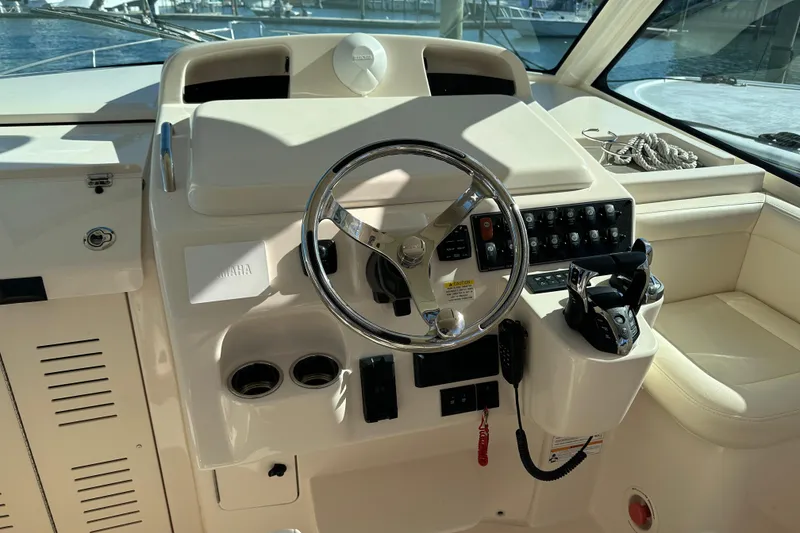 Slide: The Image of 2024 Grady-White Express 330 helm with steering wheel and control panel. - 16