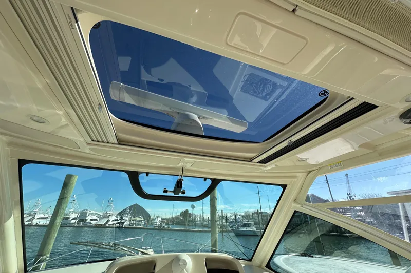 Slide: The Image of Interior view of 2024 Grady-White Express 330 boat with sunroof and marina background. - 19
