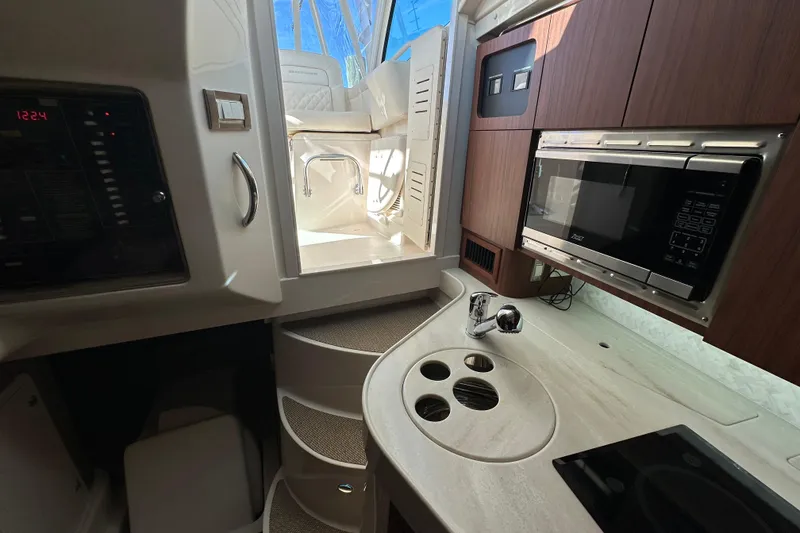 Slide: The Image of 2024 Grady-White Express 330 interior with kitchenette, microwave, and modern design. - 30