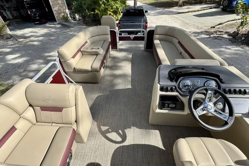 Slide: The Image of 2022 Godfrey Sweetwater 2286 C pontoon boat interior with beige seating and steering console. - 8