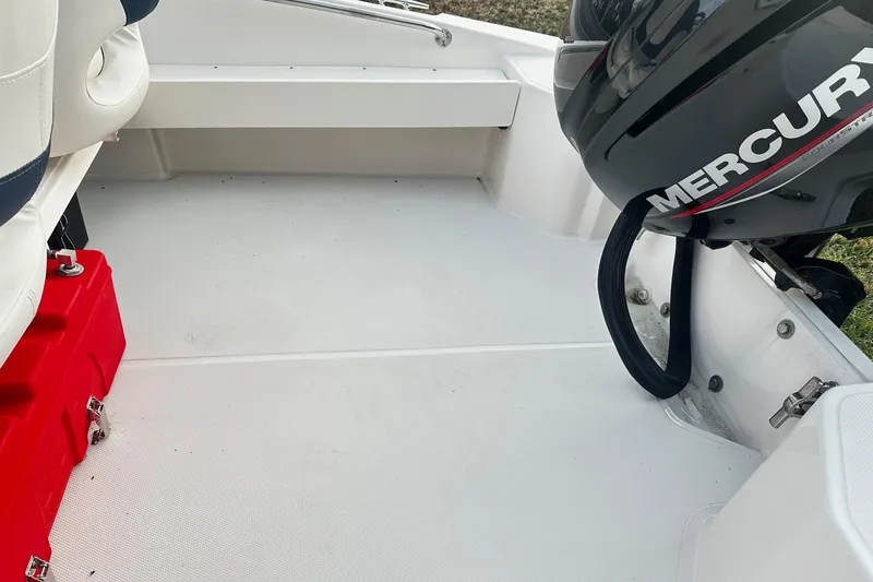Slide: The Image of 2023 Boston Whaler 160 Super Sport interior with Mercury engine and red storage box. - 12