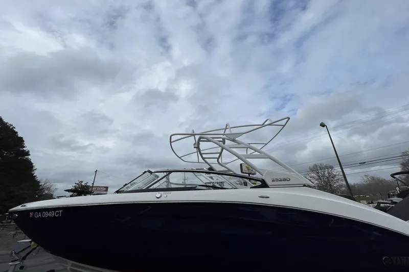Slide: The Image of 2025 Yamaha Boats 252SD under cloudy sky, side view with registration number visible. - 0