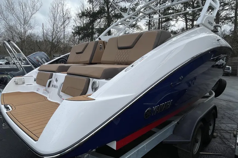 Slide: The Image of 2025 Yamaha Boats 252SD on trailer, blue hull, overcast sky background. - 1